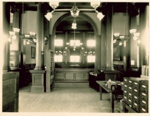 Historic interior photo of the Fulton Public Library, showing early 20th-century reading rooms, bookshelves, and period furnishings.
